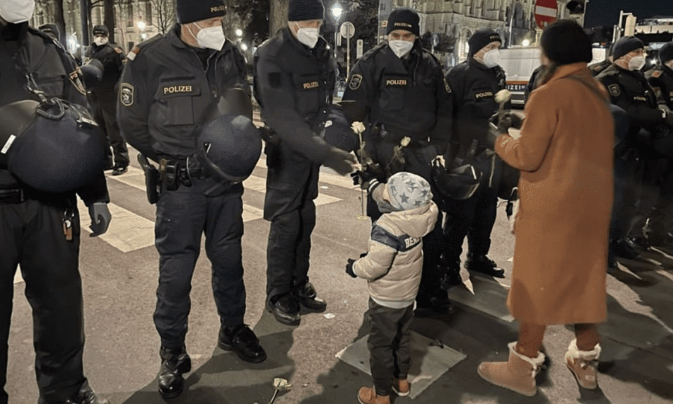 Corona-Demo, Kind überreicht Rosen an Polizei