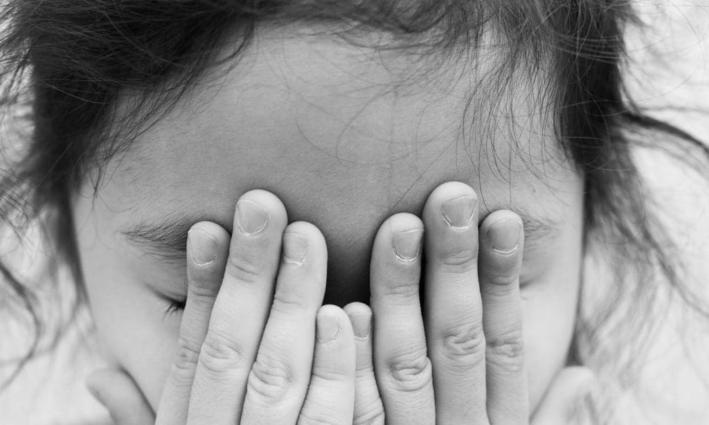 Kind mit Händen vor dem Gesicht